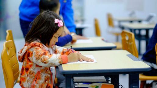 Fillette attablée en salle de classe